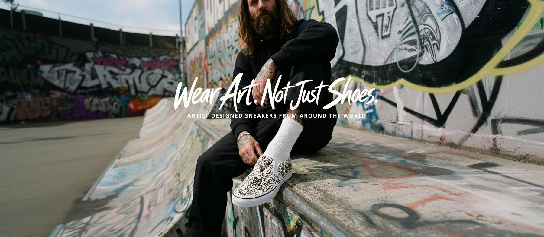 Artist wearing Sick Toes sneakers beside a graffiti wall